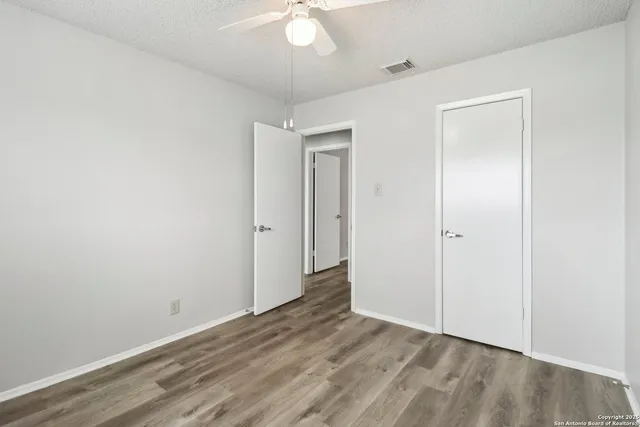 an empty room with a window and a fan