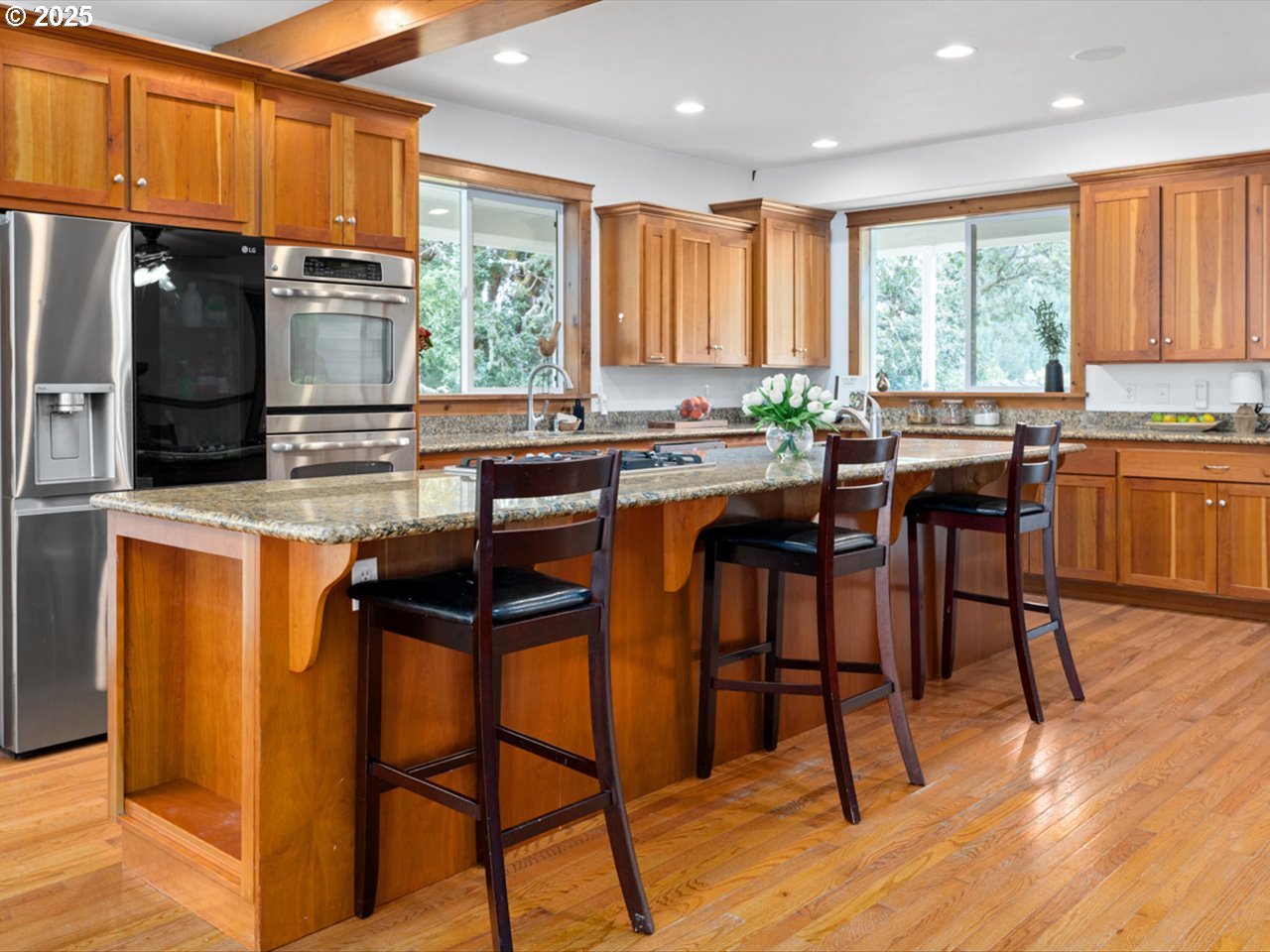 33678 Marys River Estates Road Philomath, OR 97370 - Photo 27 of 48 a kitchen with stainless steel appliances granite countertop wooden floor a stove a refrigerator a sink a dining table and chairs with wooden floor