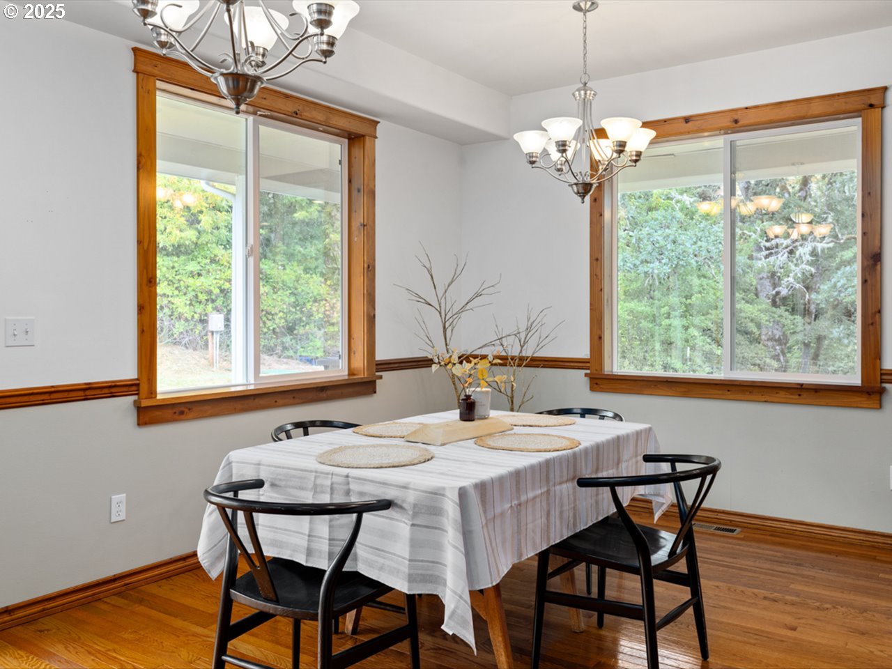 33678 Marys River Estates Road Philomath, OR 97370 - Photo 29 of 48 a dining room with wooden floor a chandelier a wooden table and chairs