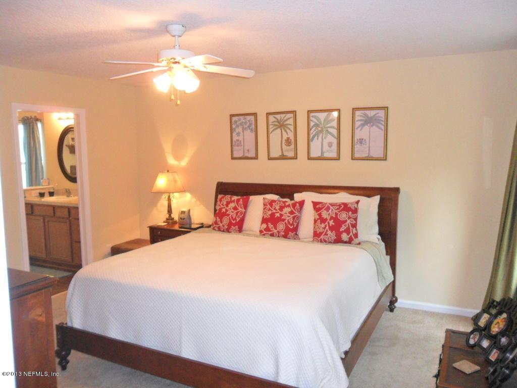 716 South Lilac Loop St. Johns, FL 32259 - Photo 18 of 22 a bedroom with a large bed and a chandelier
