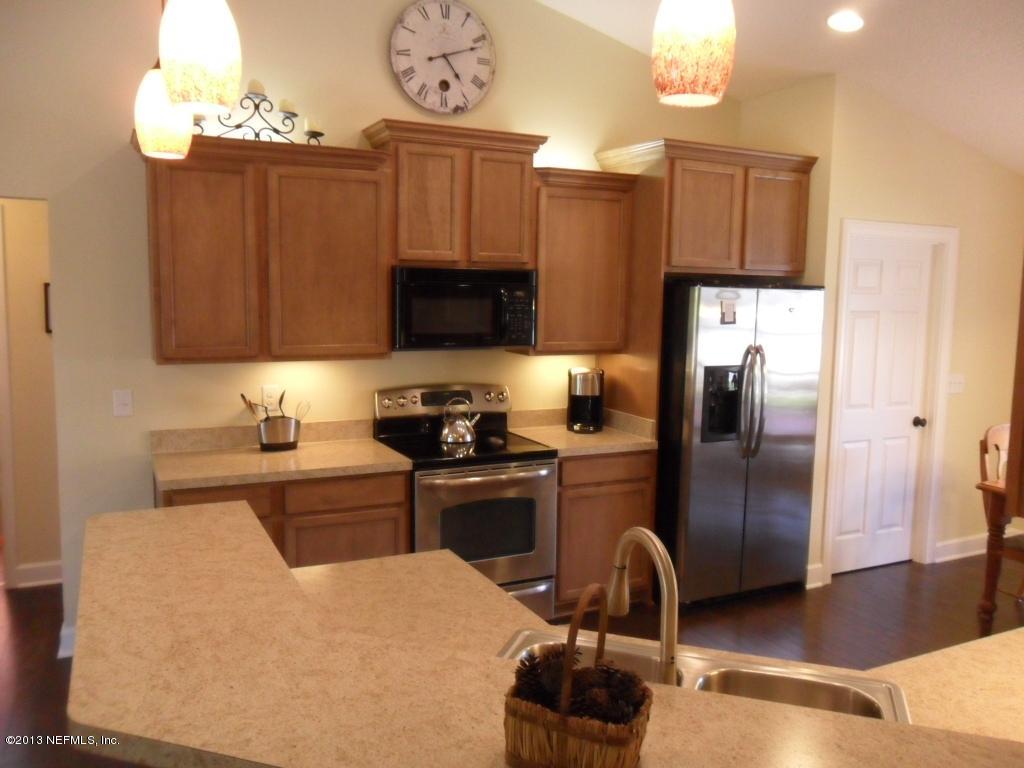 716 South Lilac Loop St. Johns, FL 32259 - Photo 8 of 22 a kitchen with granite countertop a refrigerator stove top oven and sink