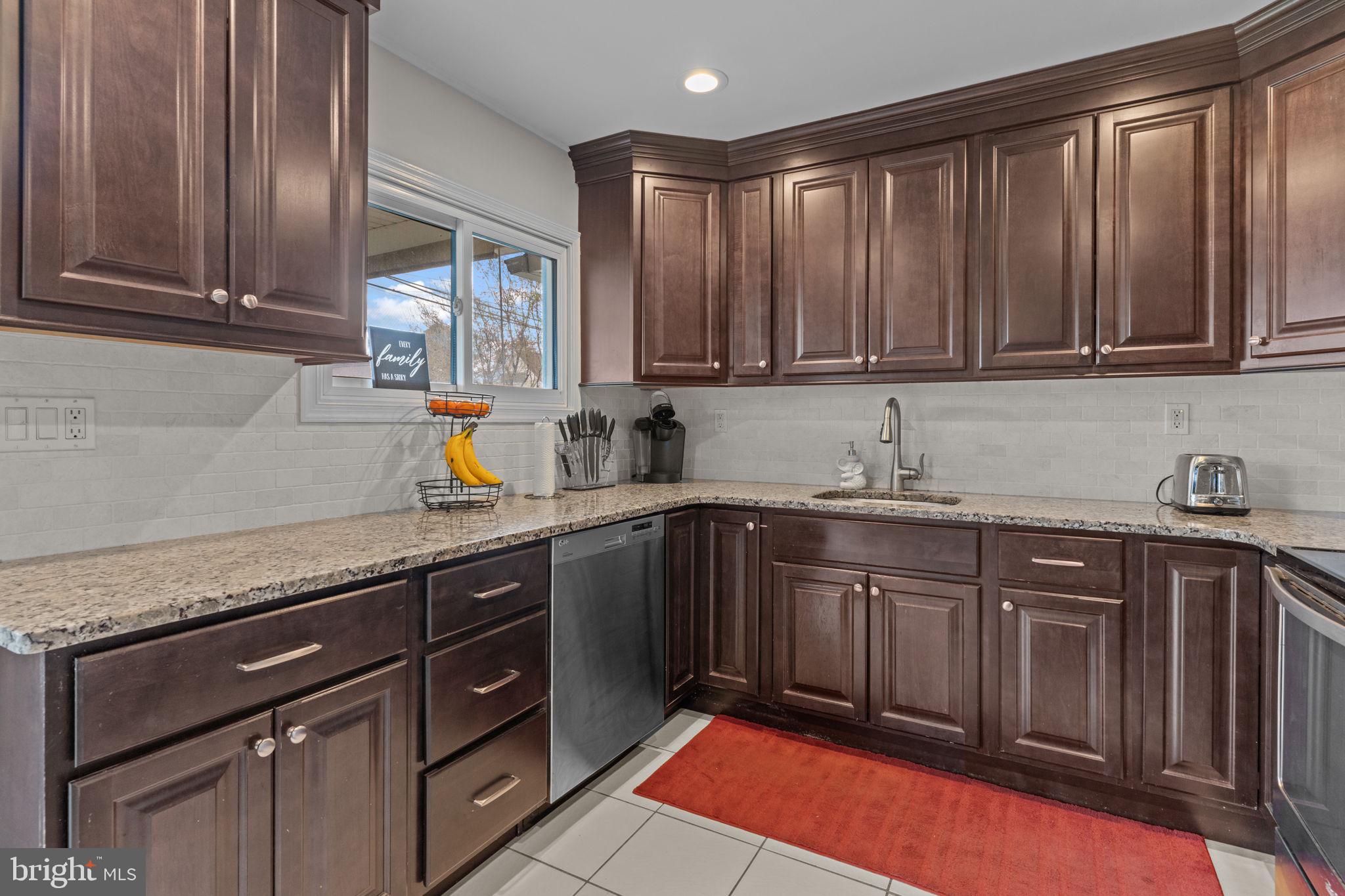 58 Tinder Road Levittown, PA 19056 - Photo 7 of 20 a kitchen with stainless steel appliances granite countertop a sink stove and cabinets