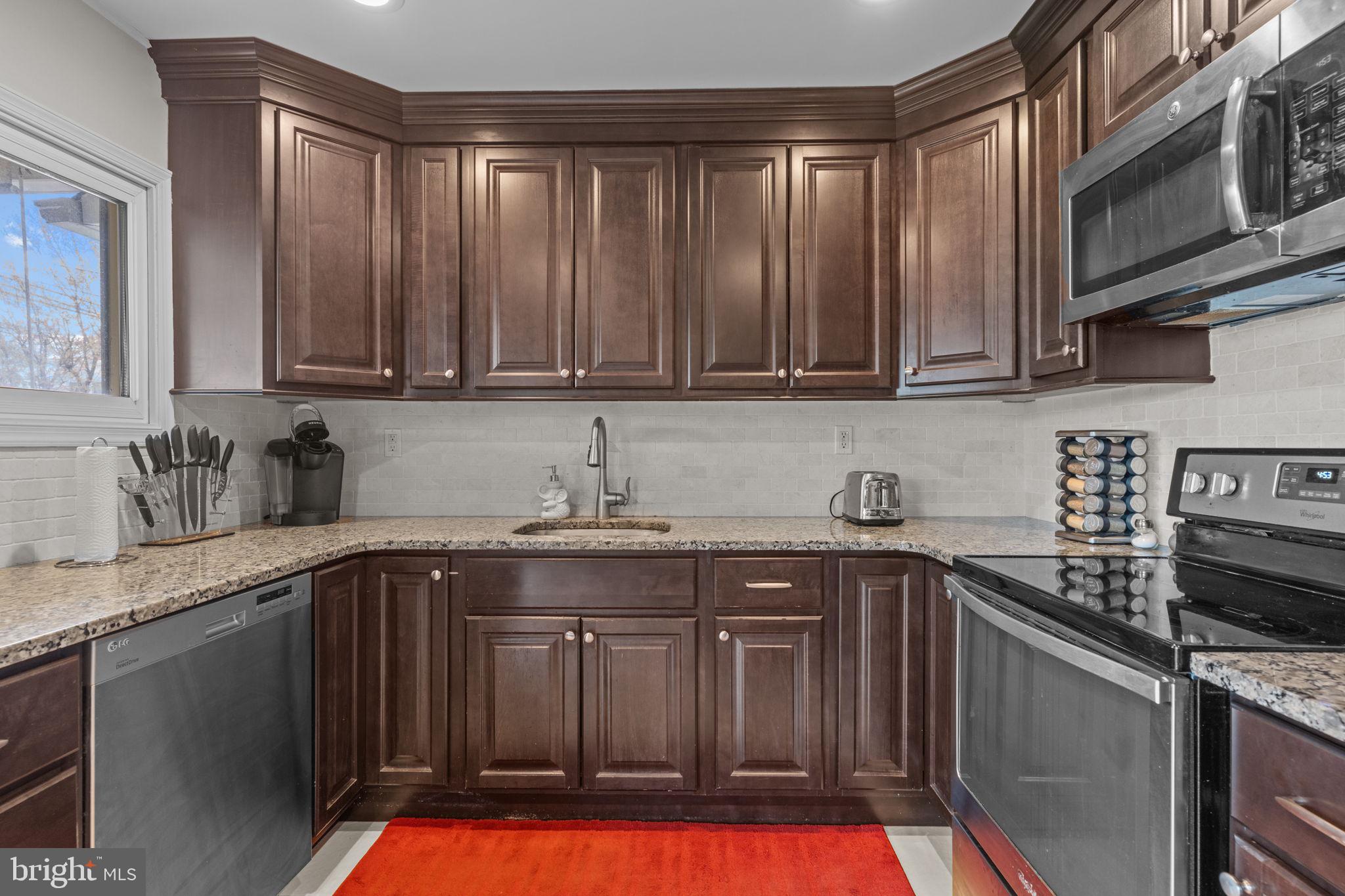 58 Tinder Road Levittown, PA 19056 - Photo 8 of 20 a kitchen with stainless steel appliances granite countertop a stove a sink dishwasher and cabinets with wooden floor