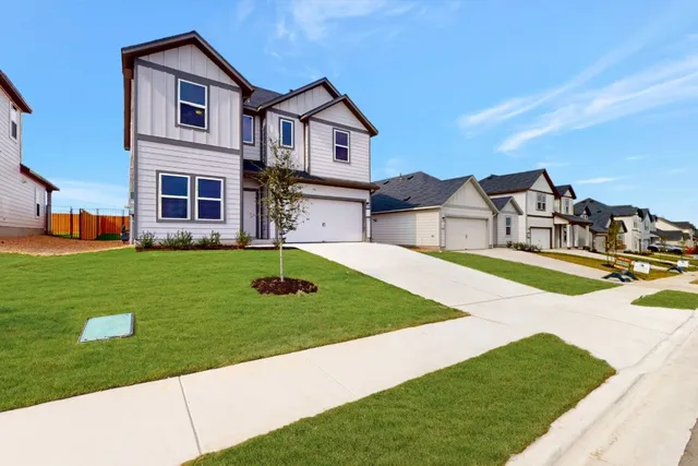 a view of a house with a big yard and large trees