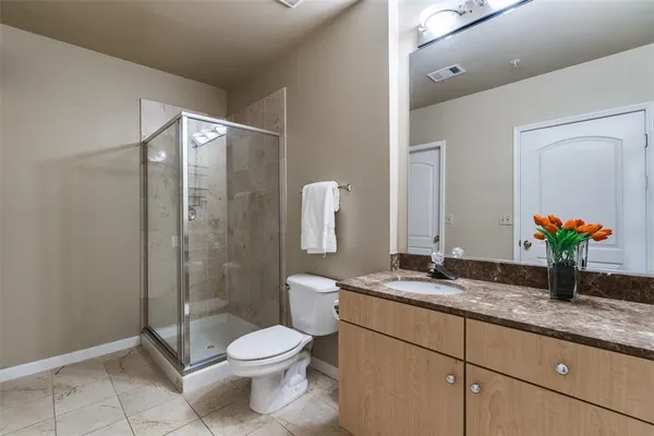 a bathroom with a granite countertop toilet sink and shower