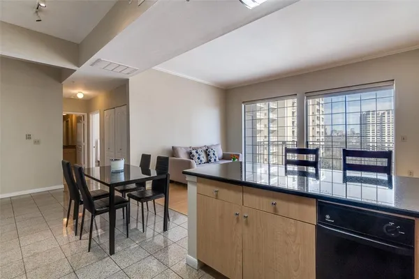 a dining hall with stainless steel appliances granite countertop a stove a sink a dining table and chairs