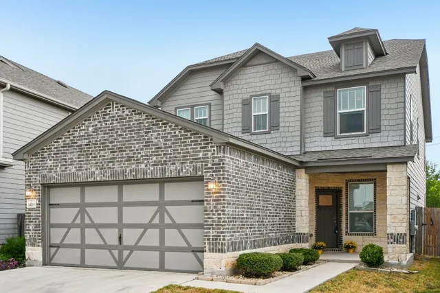 a front view of a house with a garden
