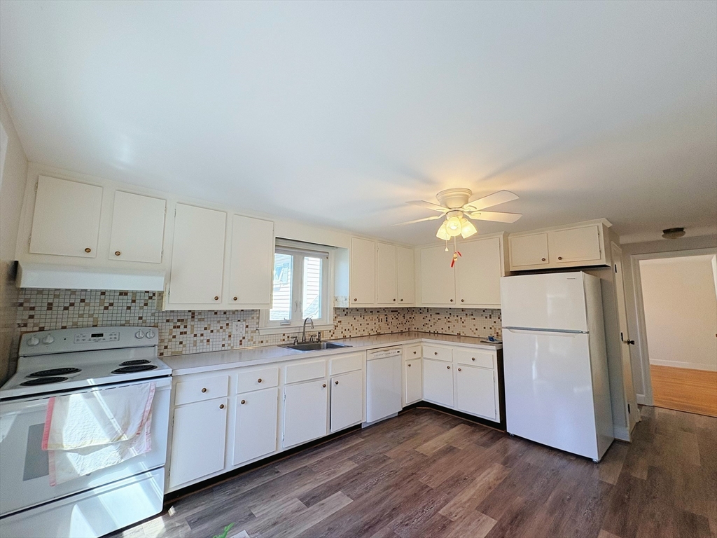 55 Sutherland Road, Unit 55 Arlington, MA 02476 - Photo 13 of 23 a kitchen with a refrigerator a sink and dishwasher with wooden floor
