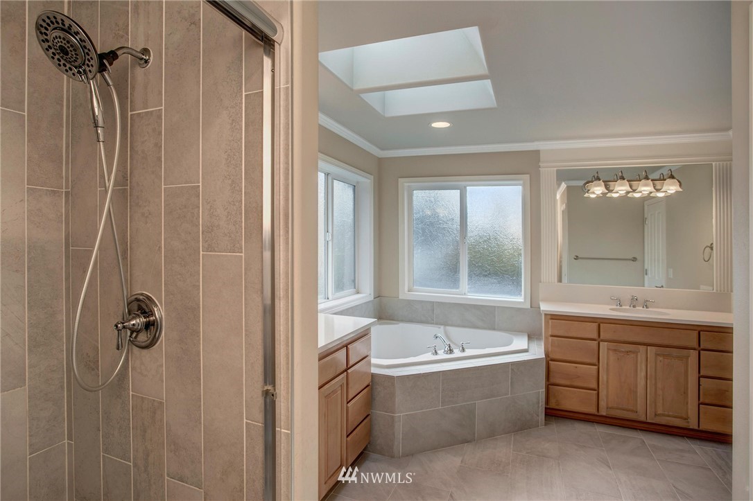 4014 215th Street Southeast Bothell, WA 98021 - Photo 16 of 25 a bathroom with a tub sink shower and mirror
