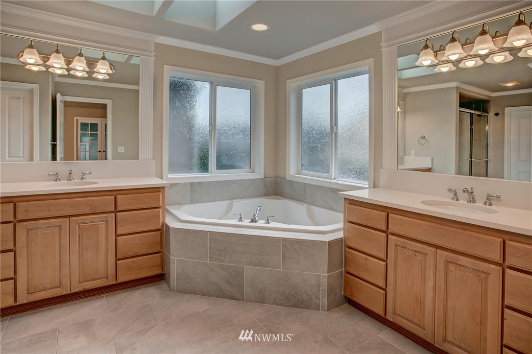4014 215th Street Southeast Bothell, WA 98021 - Photo 17 of 25 a bathroom with a tub a double vanity sink a vanity a window and a mirror