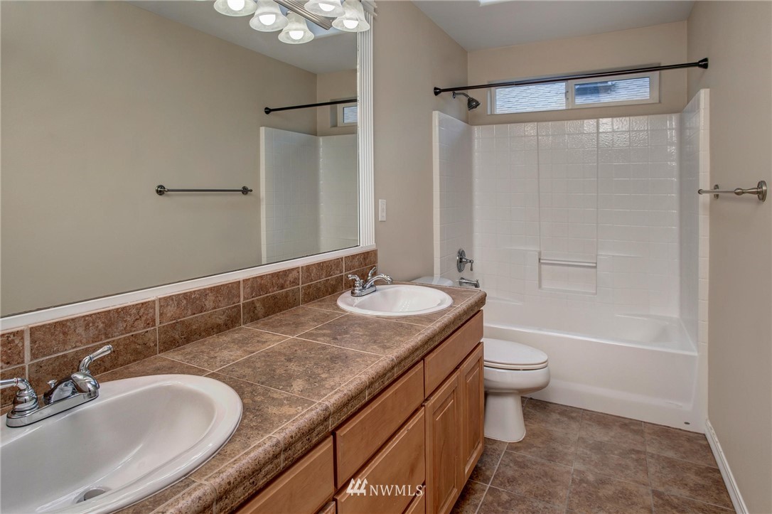 4014 215th Street Southeast Bothell, WA 98021 - Photo 21 of 25 a bathroom with a granite countertop sink toilet a mirror and shower