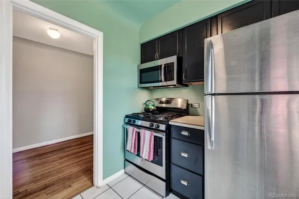 a kitchen with stainless steel appliances granite countertop a refrigerator and a stove top oven