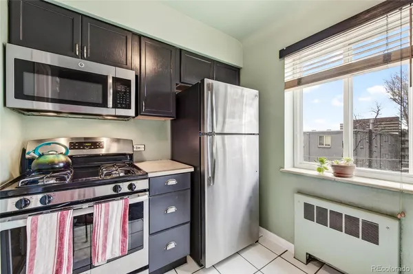 a kitchen with stainless steel appliances granite countertop a refrigerator a stove a sink and a microwave