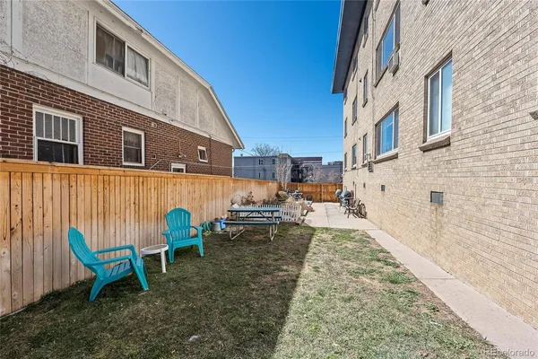 a view of a chairs and table in the backyard