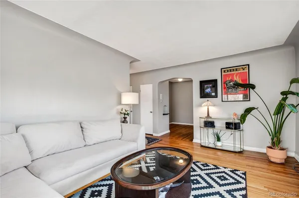 a living room with furniture and a wooden floor