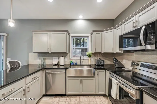 a kitchen with a sink cabinets and stainless steel appliances