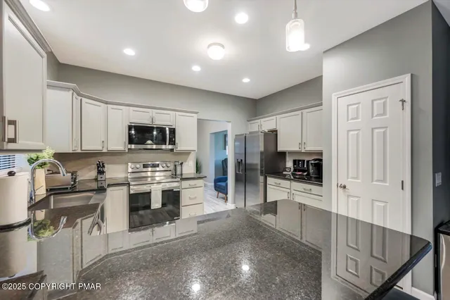 a large kitchen with cabinets wooden floor and stainless steel appliances
