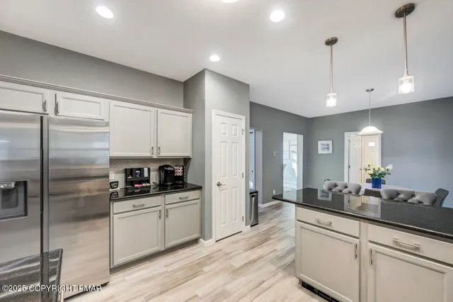 a kitchen with stainless steel appliances a sink a stove a refrigerator and cabinets