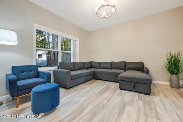 a living room with furniture and a wooden floor