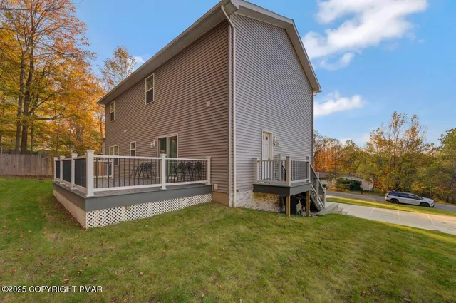 a front view of a house with a yard and lake view