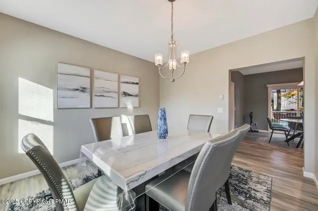 a view of a dining room with furniture a chandelier and wooden floor