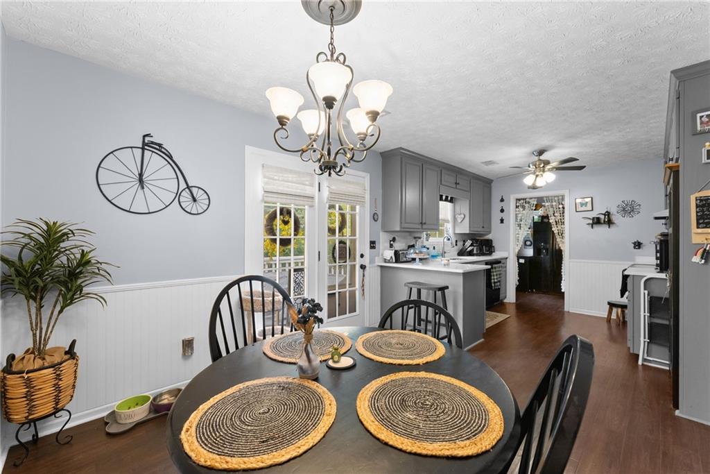 3615 South Bend Road Gainesville, GA 30506 - Photo 17 of 54 a dining room with wooden floor a chandelier a wooden table and chairs