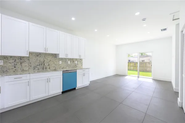 a open kitchen with granite countertop a stove a sink and a granite counter tops