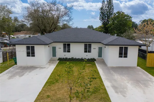 a view of house with garden space and a tree