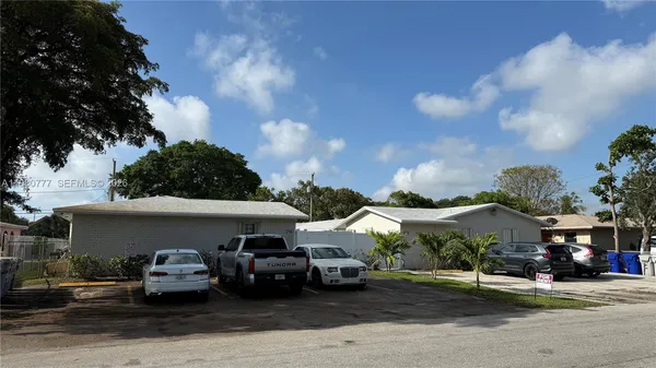 a front view of a house with cars parked