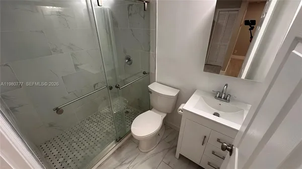 a white toilet sitting next to a bathroom sink and vanity