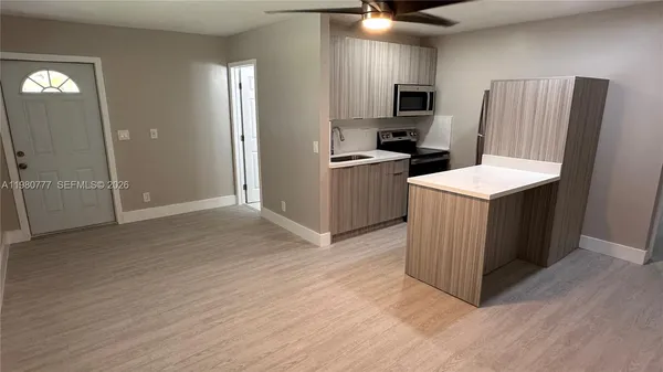 a kitchen with a refrigerator and a stove top oven