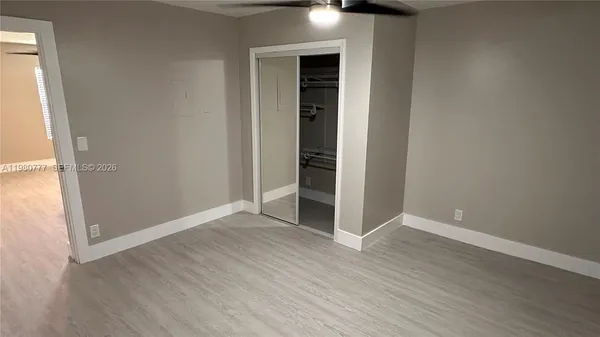 an empty room with wooden floor and entrance
