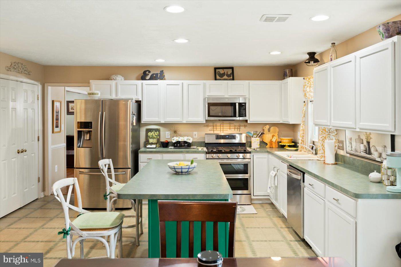 8472 Colfax Drive King George, VA 22485 - Photo 15 of 62 a kitchen with stainless steel appliances a refrigerator stove microwave and cabinets