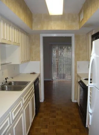 a kitchen with a refrigerator and a stove top oven