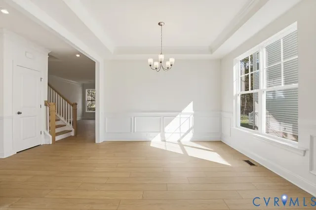 a view of a livingroom with wooden floor and a chandelier