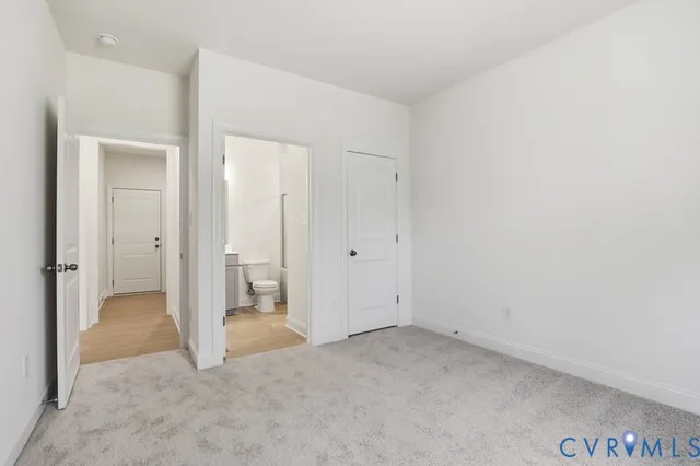 an empty room with white cabinet and bathroom