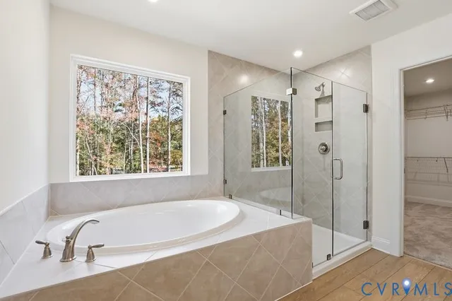 a bathroom with a tub a sink and glass door