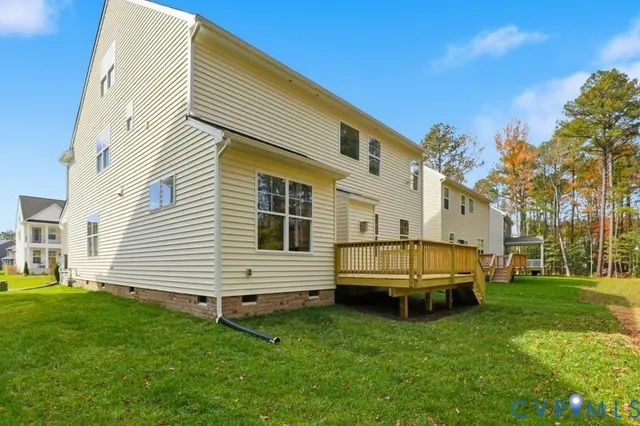 a view of a white house with a big yard with wooden fence