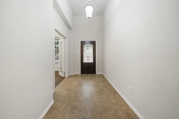 a view of a hallway with wooden floor and a window