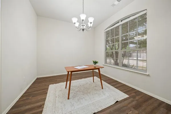 a room with chandelier and wooden floor