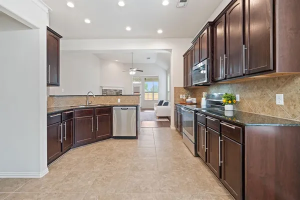 a kitchen with stainless steel appliances granite countertop a stove top oven a sink and dishwasher