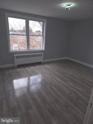 a view of a room with wooden floor and window