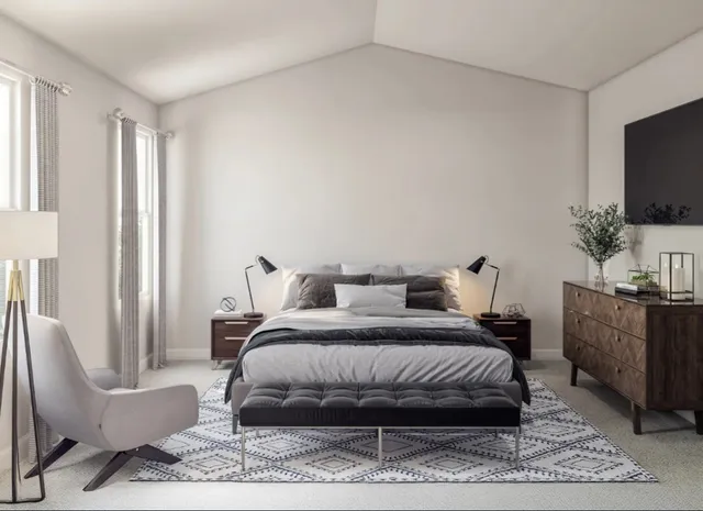 a bedroom with a bed a couch and a flat screen tv