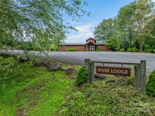a view of a house with a yard and large tree