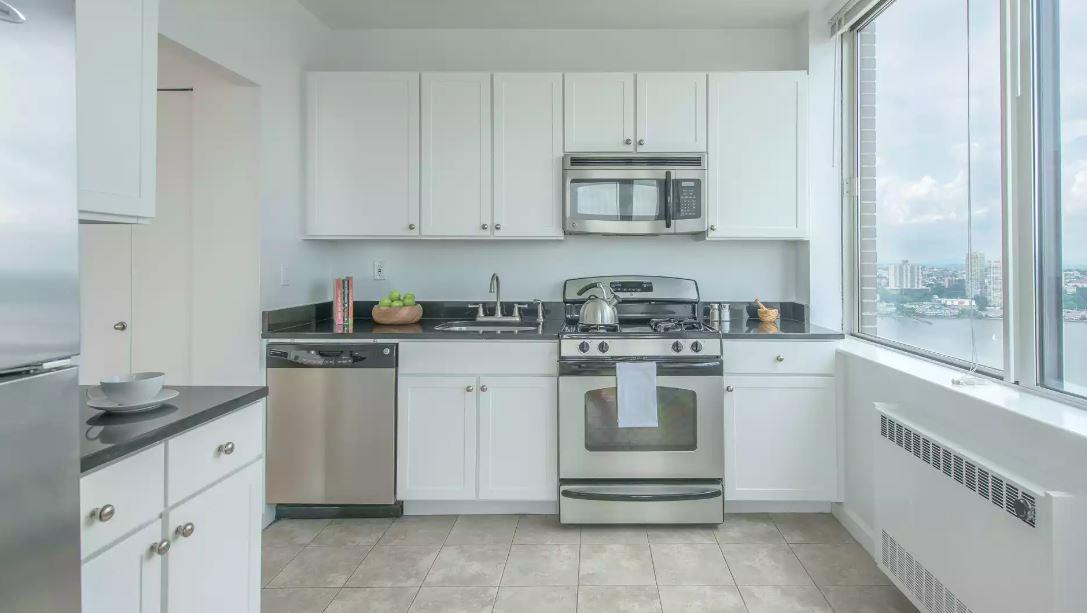 180 Riverside Boulevard, Unit 609 Manhattan, NY 10069 - Photo 1 of 9 a kitchen with white cabinets and white appliances