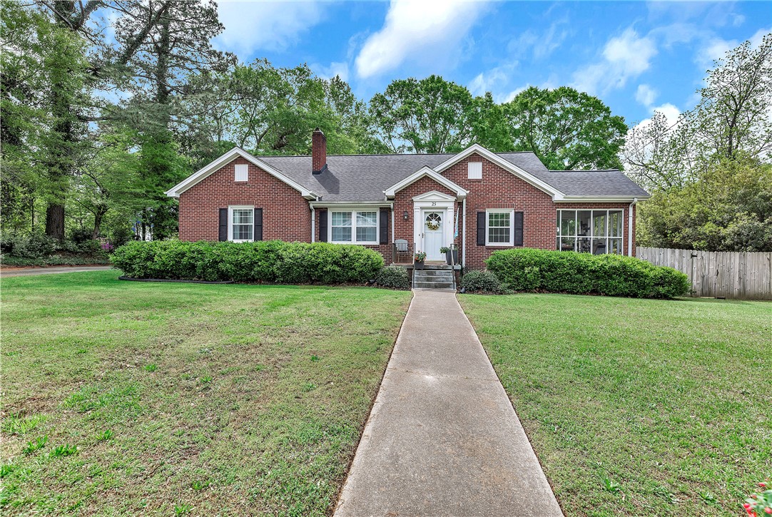 This brick residence offers a classic facade with lush lawn and mature trees.
