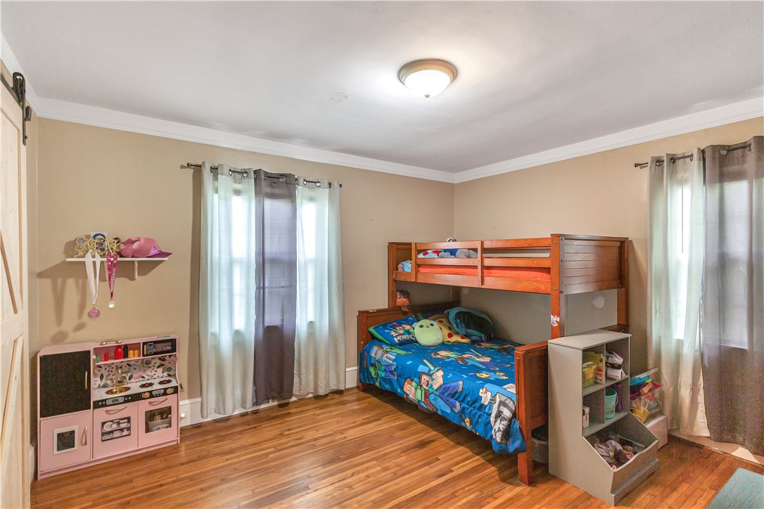 25 Central Avenue Honea Path, SC 29654 - Photo 14 of 29 This inviting bedroom features rich hardwood flooring and elegant crown molding.