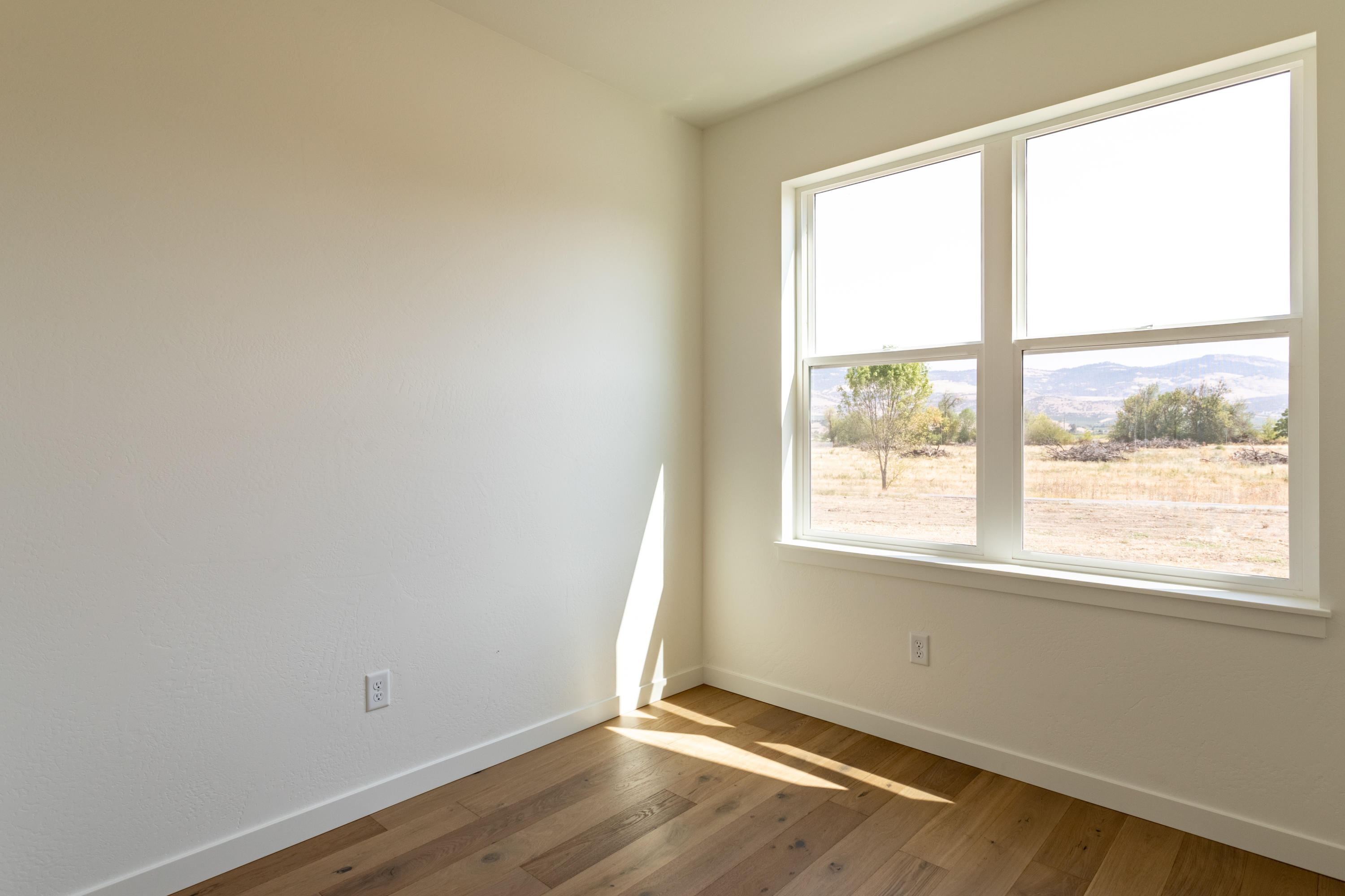 5607 Colver Road Talent, OR 97540 - Photo 22 of 34 an empty room with wooden floor and windows