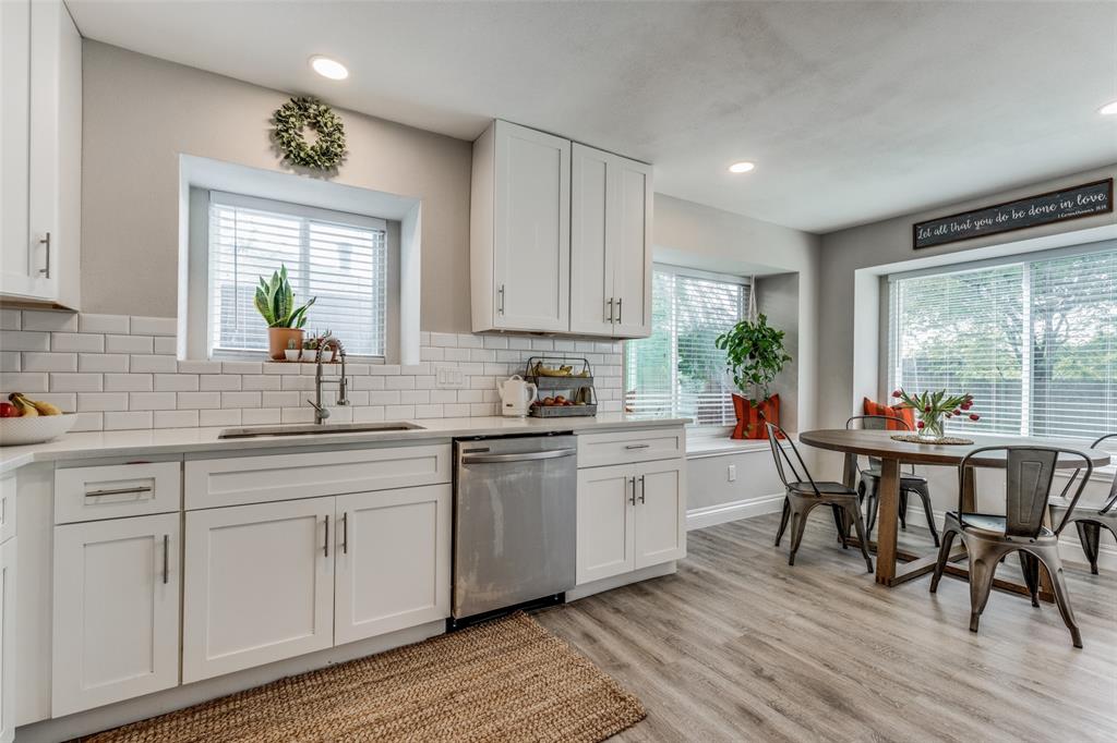 3113 Colony Drive Mesquite, TX 75150 - Photo 1 of 1 a kitchen with white cabinets wooden floor dining table and stainless steel appliances