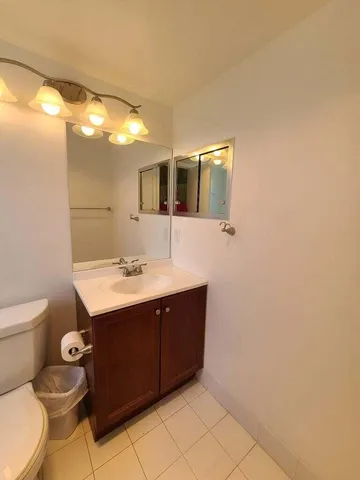 a bathroom with a sink mirror vanity and toilet